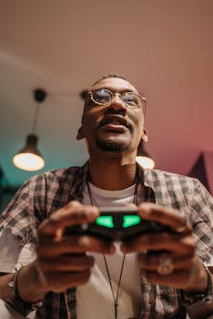 Focused man playing video game with controller indoors during day.