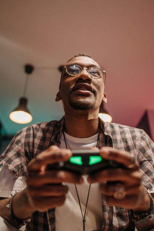 Low-Angle Shot of Man Holding a Game Controller · Free Stock Photo