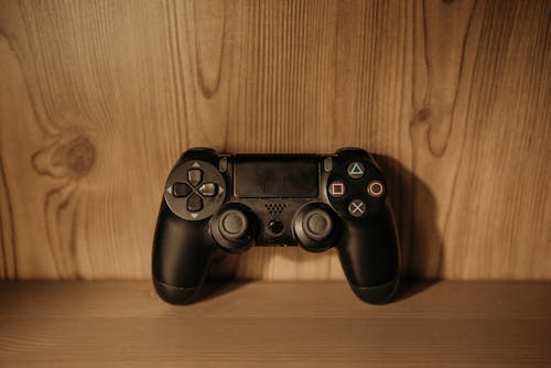 Black Game Controller on Wooden Surface