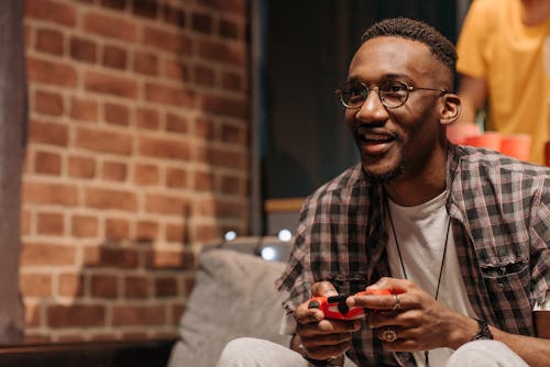 A Man Wearing a Plaid Shirt Playing a Video Game