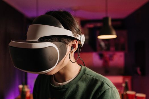 A person immersed in virtual reality using a VR headset and headphones indoors.