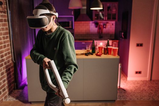 Teen playing VR game in a cozy living room with vibrant lighting.