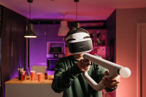 A Person in Green Long Sleeves Playing with VR Controller