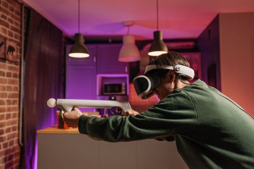 A young adult using a VR headset and controller in a cozy home setting, fully engaged in virtual reality gaming.