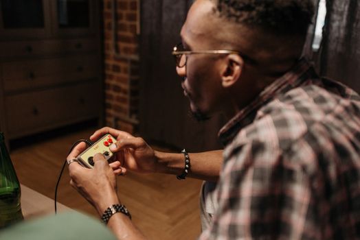 Focused young man playing video games at home with enthusiasm.