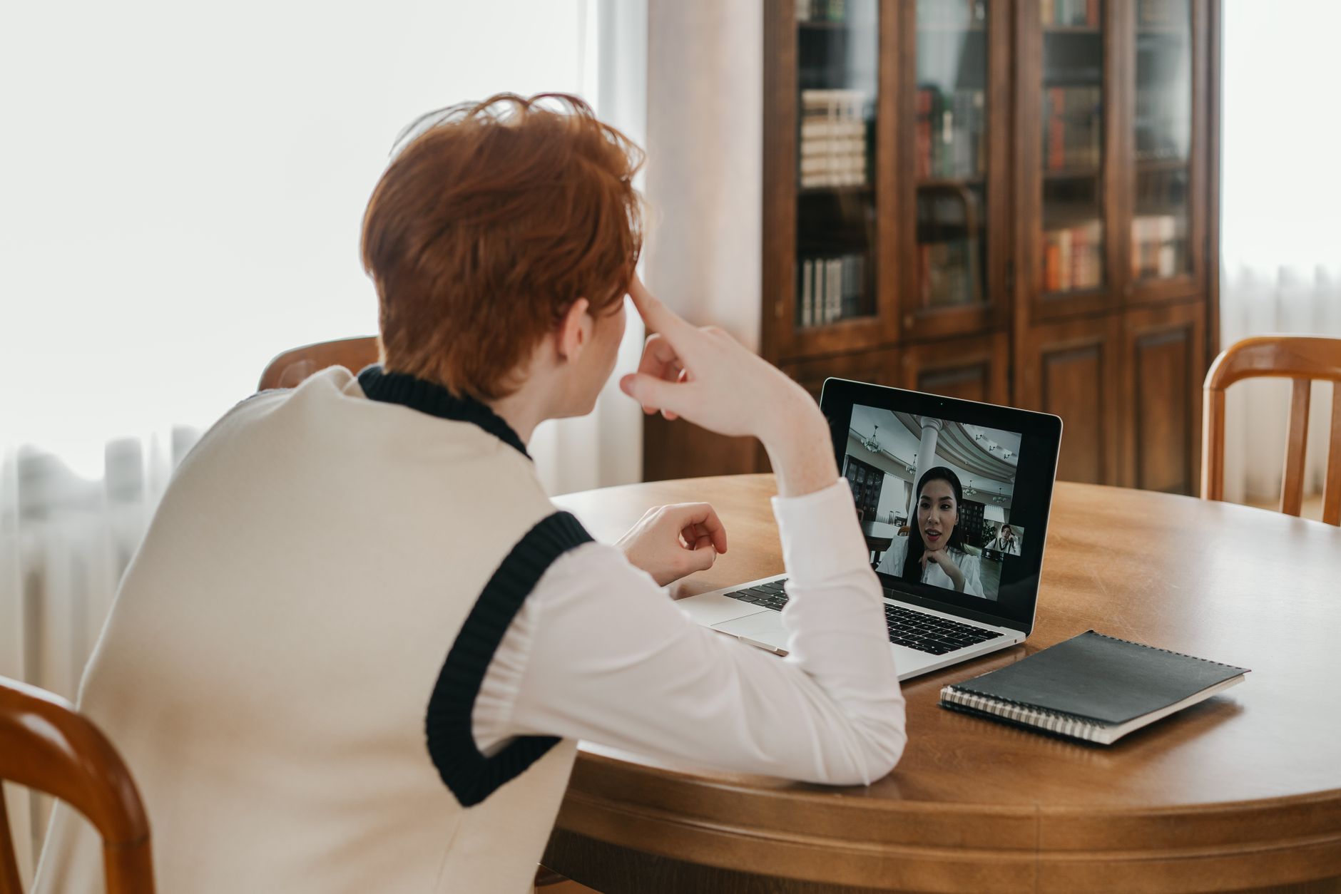 A person sitting in front of a computer screen talking to a character