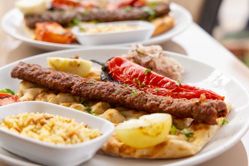 Free A mouth-watering close-up of a Middle Eastern kebab dish served with rice and vegetables. Stock Photo