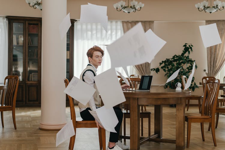 Young Man Throwing Papers And Feeling Upset