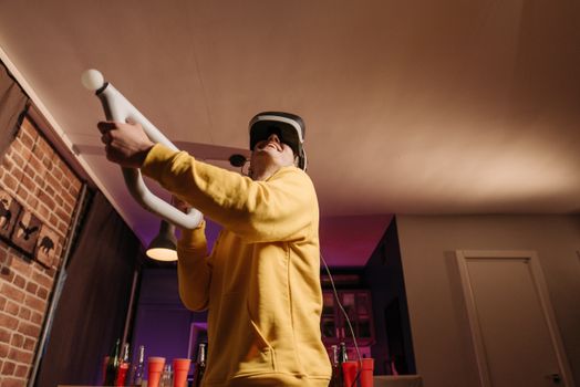 A young adult engages in immersive virtual reality gaming in a cozy living room setting.
