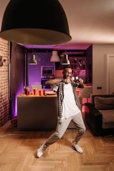 A young man plays a video game in a stylish living room with modern decor and moody lighting.