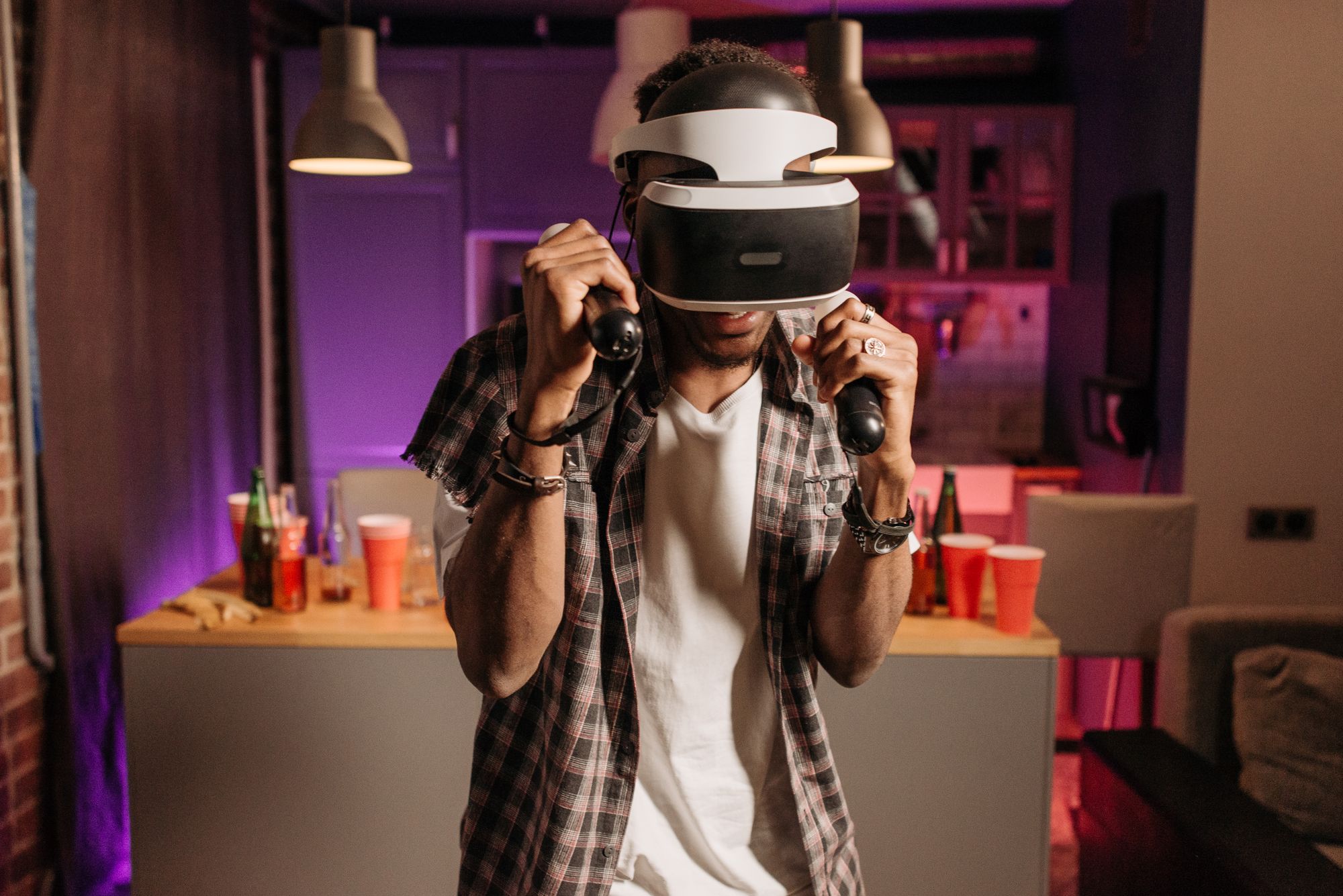 Persona con un visor de realidad virtual jugando en la sala de su casa