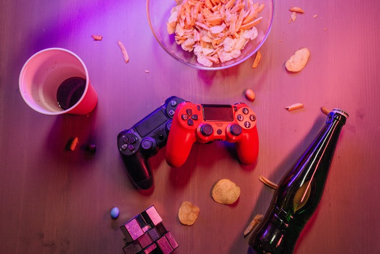 Messy Table With Game Controllers And A Beer Bottle