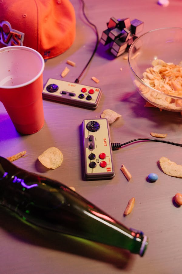 Black Remote Control Beside Green Glass Bottle