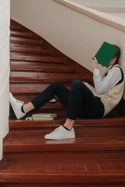 Student Sprawled on the Stairs Covering His Face with a Notebook