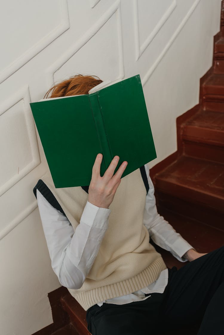 Man Covering His Face With A Book