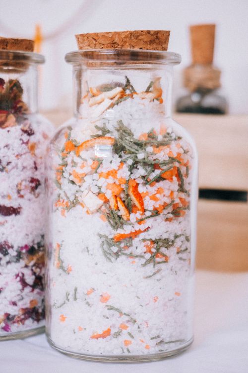 Free Vibrant bath salts with herbs in glass jars, perfect for relaxation and spa decor. Stock Photo