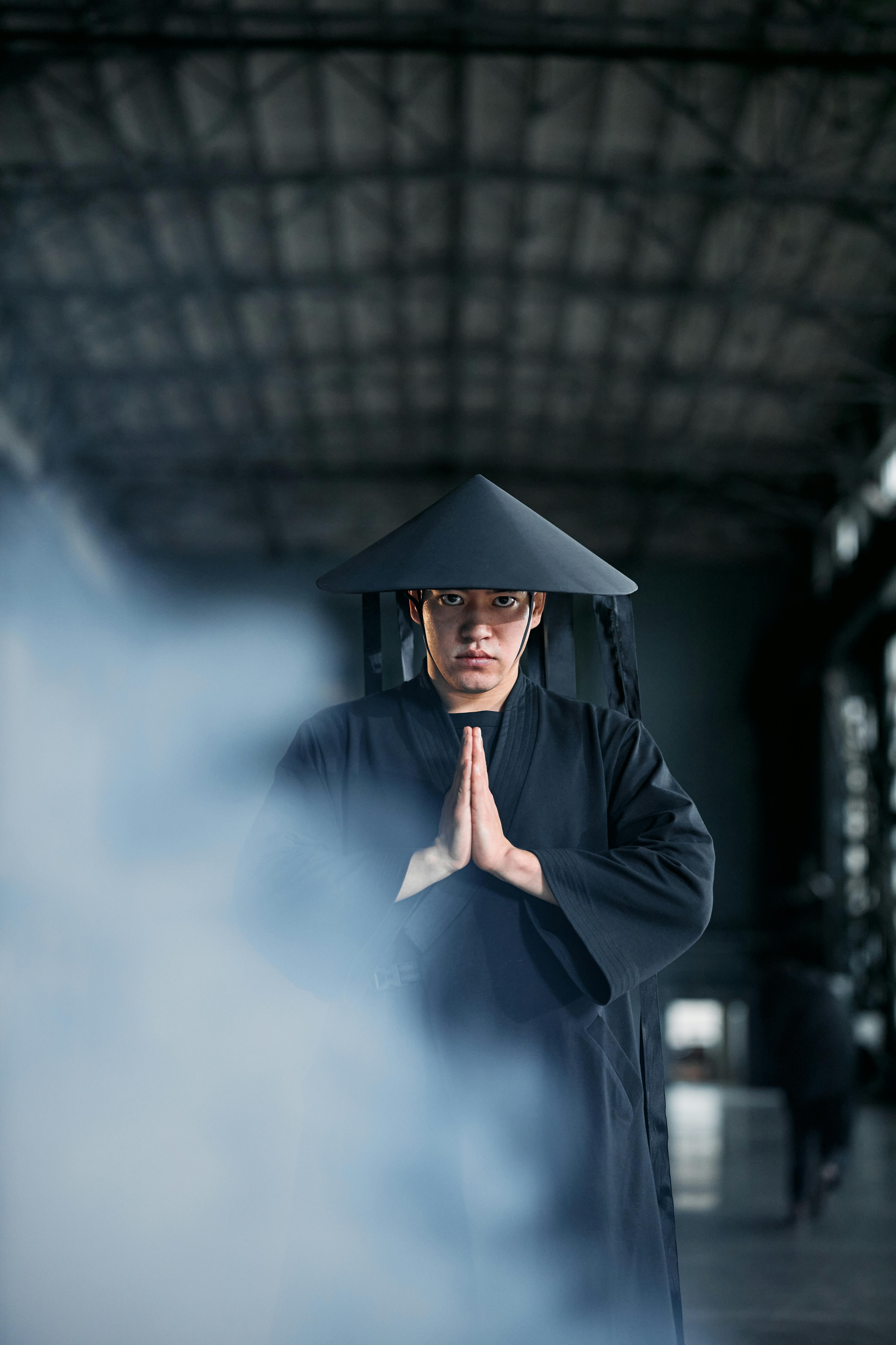 Free An Asian man in cosplay, posing with hands together in an indoor setting. Stock Photo