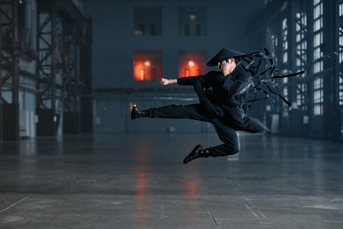 Military man in camouflage holding gun at sunset