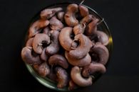 Top view of raw cashew nuts piled in a bowl, perfect for food and ingredient themes.