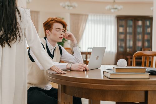 Free Two young adults in a cozy living room working on a laptop, fostering communication and teamwork. Stock Photo