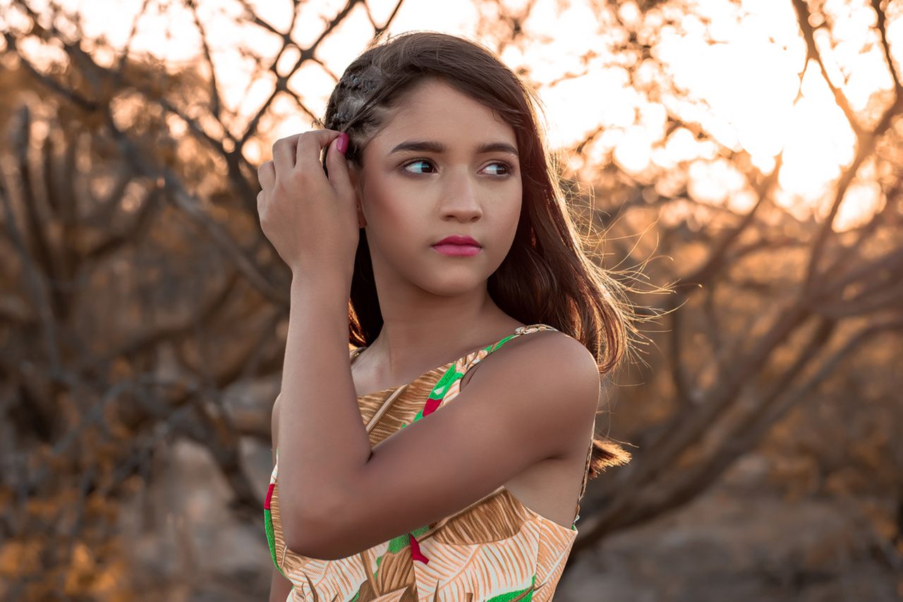 serene portrait of a young woman outdoors at sunset with soft backgrou