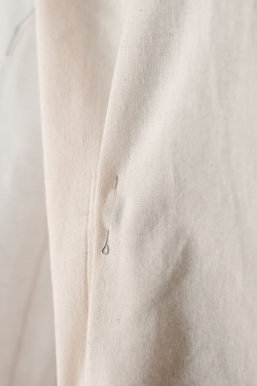 Close-Up Photo of a Pin in a White Cloth