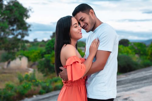 Free A couple happily embracing against a scenic natural backdrop, symbolizing love and connection. Stock Photo