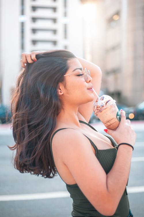  A Woman Drinking a Blended Coffee Drink with a Straw