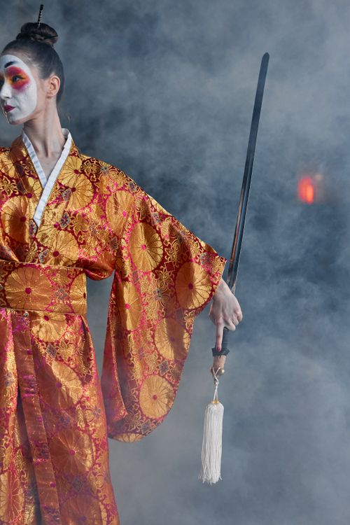 Free Elegant woman in kimono holding a sword amidst smoke, showcasing traditional Japanese style. Stock Photo