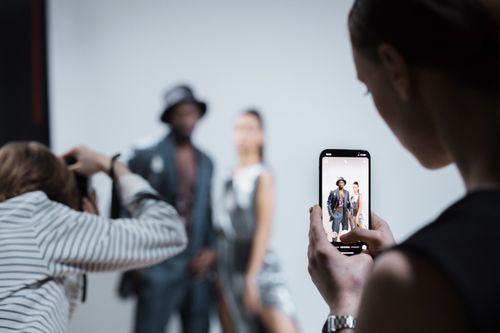 Free Fashion models being photographed in a professional studio setting with smartphone capture. Stock Photo