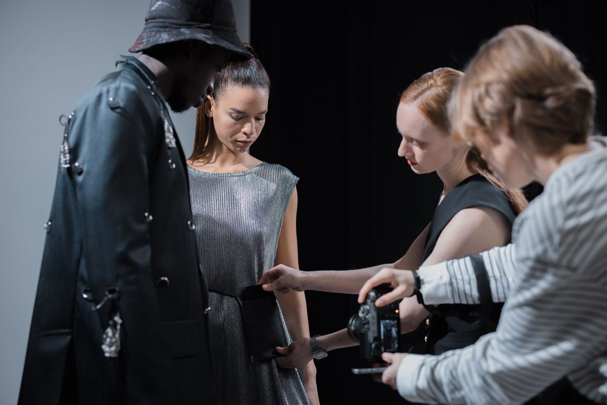 Models and a designer collaborating during a studio fashion shoot