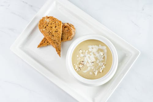 Close-Up Shot of Soup in a Bowl beside a Bread