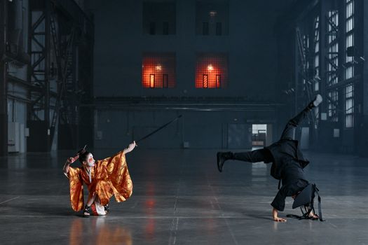 A martial arts duel with costumes and swords in a vast industrial warehouse.