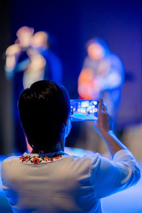 Selective Focus of a Person Holding a Cellphone while Taking Photo