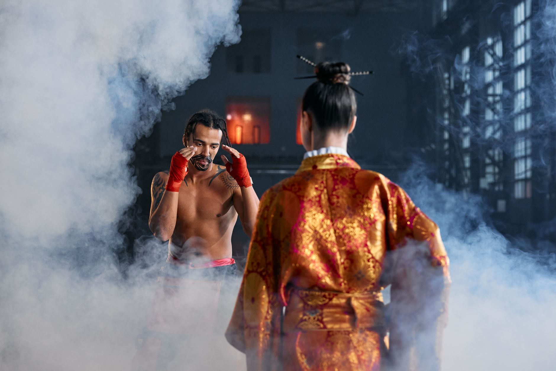 Two martial artists in traditional attire face off in a dramatic, smoke-filled arena.