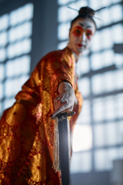 A Woman in Traditional Wear Holding a Sword