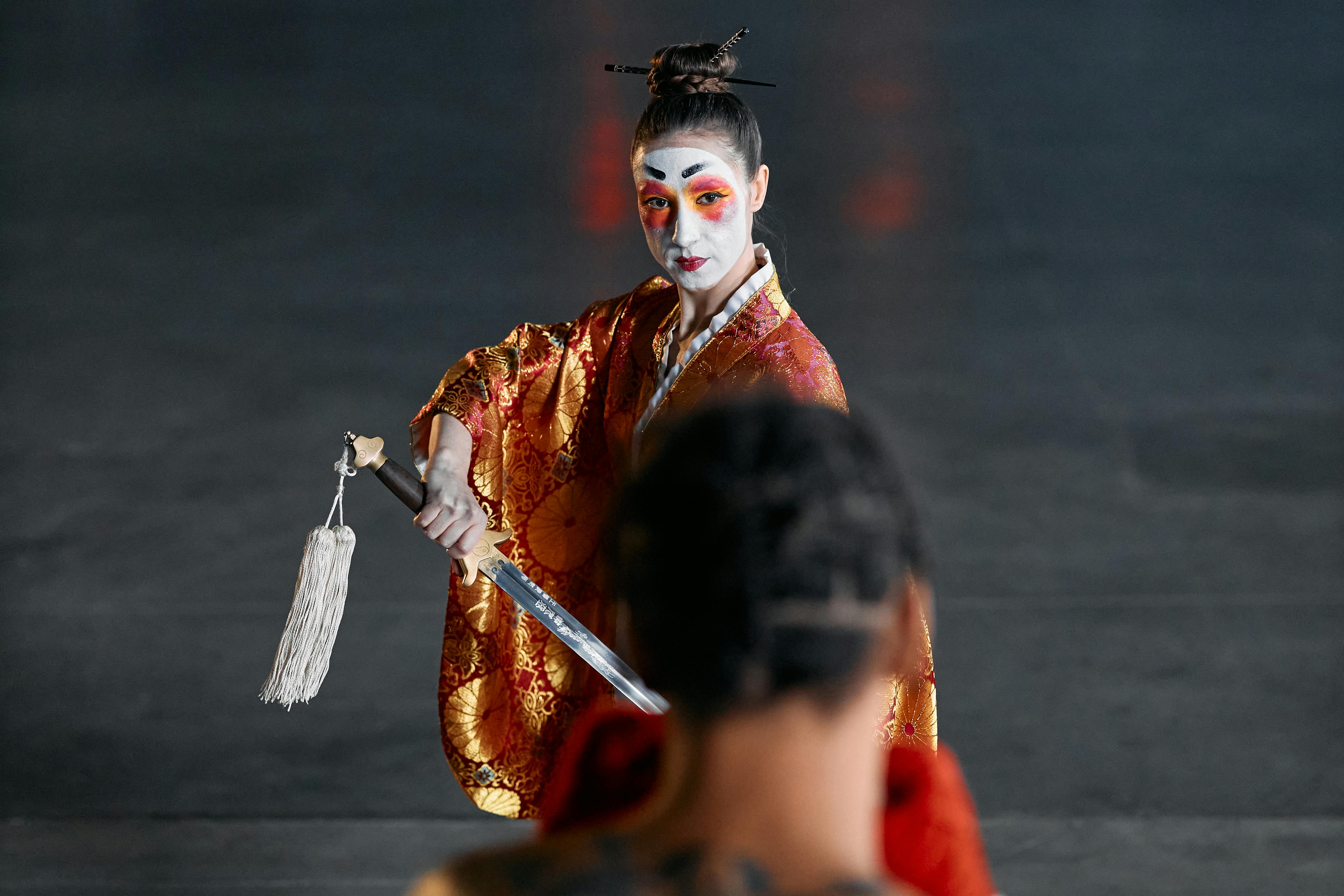 Free A striking image of a woman in traditional Japanese costume holding a katana, embodying a cosplay warrior spirit. Stock Photo