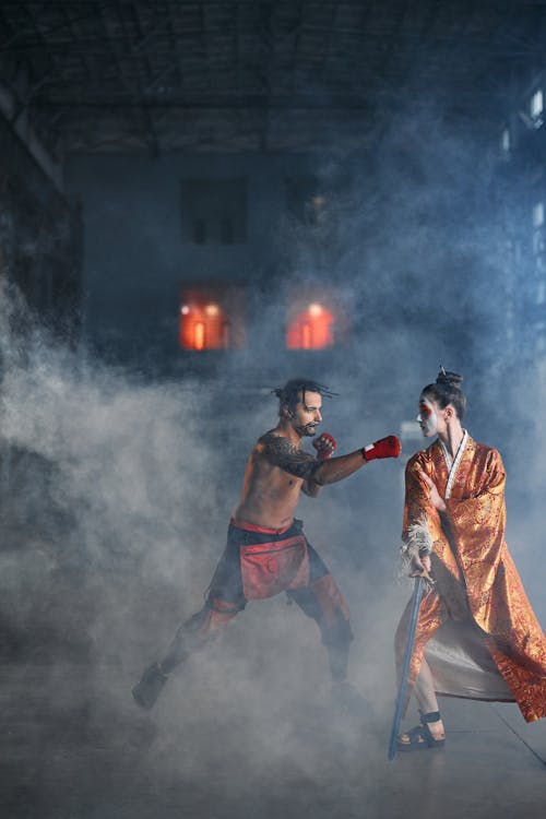 Free A Shirtless Man Punching a Person in Orange Traditional Wear Stock Photo