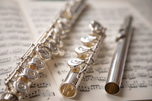 Elegant silver flutes resting on sheet music, showcasing classic musical beauty.