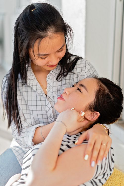 Free A tender and affectionate moment captured between two women embracing indoors, exuding warmth and love. Stock Photo