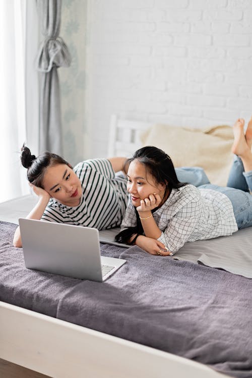 Women Watching on a Laptop while Lying Down