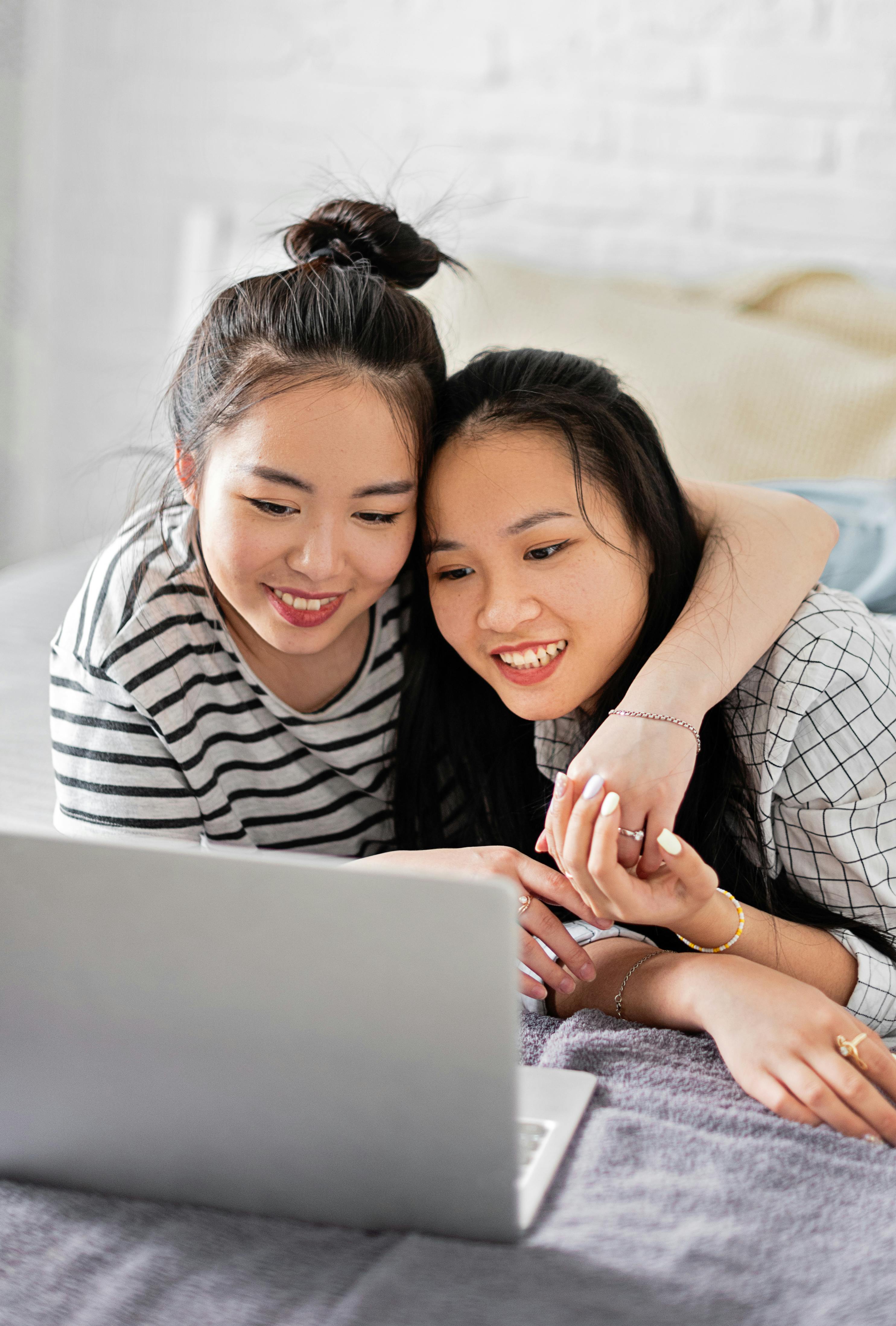 two women looking the laptop together