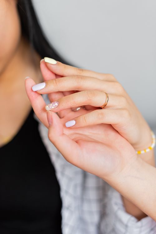 Free A close-up image of two women holding hands with beautifully painted nails displaying friendship and connection. Stock Photo