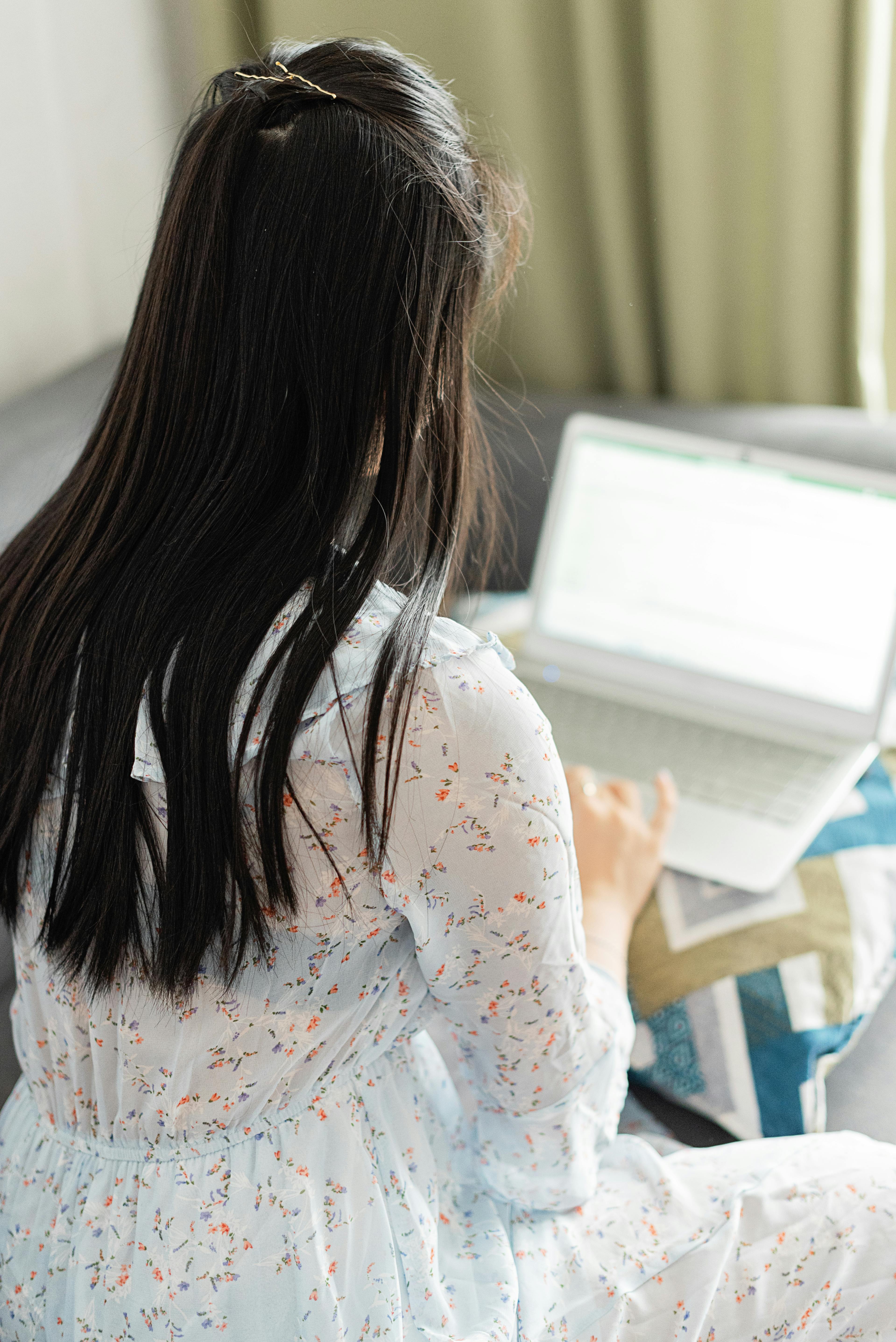 woman in floral dress using a laptop