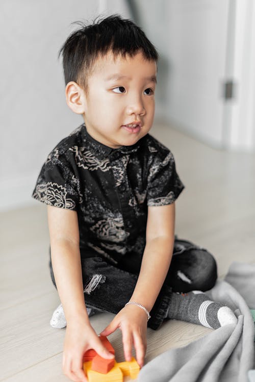 Boy in Black Shirt Sitting on the Floor
