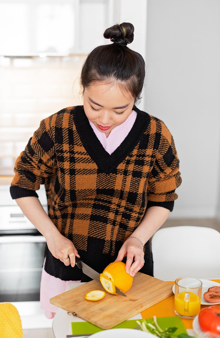 Woman In Plaid Vest Slicing Orange