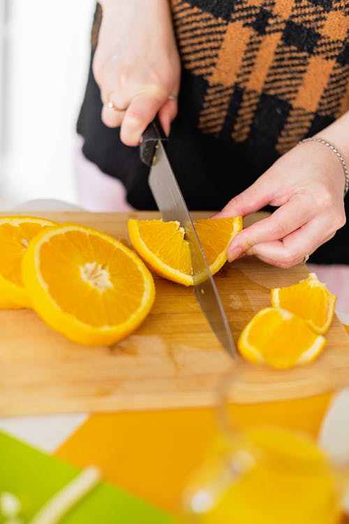 Free Person Holding Stainless Steel Knife Slicing Orange Fruit Stock Photo
