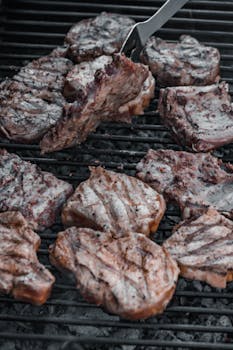 Close-up of succulent steaks sizzling on a hot grill, perfect for a barbecue feast.