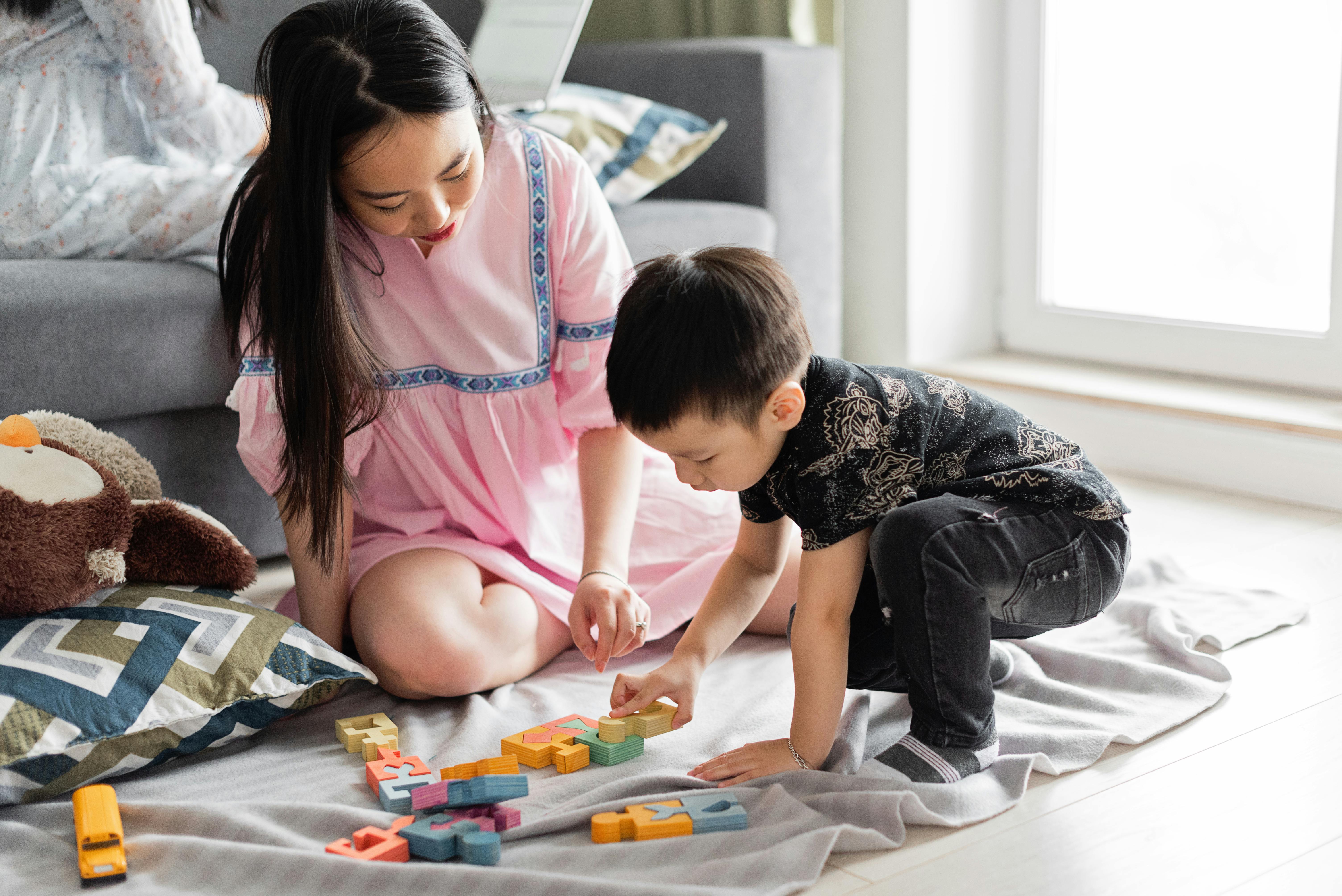 woman playing with her son on the floor