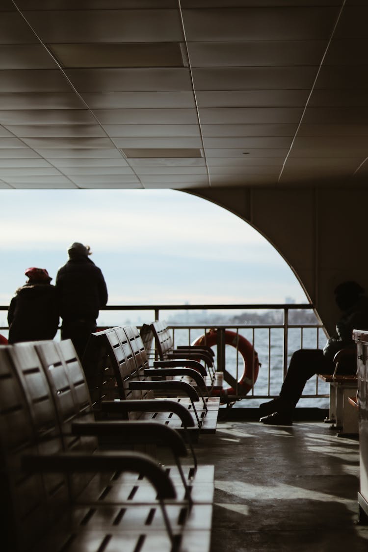 Silhouette Of Travelers Waiting For Ferry In Landing Stage